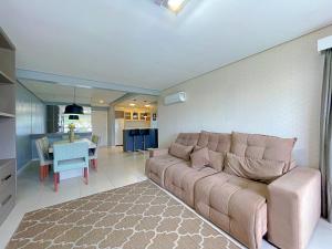 ein Wohnzimmer mit Couch und ein Esszimmer in der Unterkunft Espaçoso apto no Centro de Gramado in Gramado