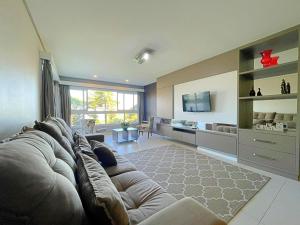 ein großes Wohnzimmer mit einem Sofa und einem TV in der Unterkunft Espaçoso apto no Centro de Gramado in Gramado