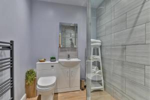 bagno con servizi igienici, lavandino e specchio di Serenity Guest House a Scarborough