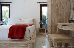 um quarto com uma cama com um cobertor vermelho em Villa Kaya em Seminyak