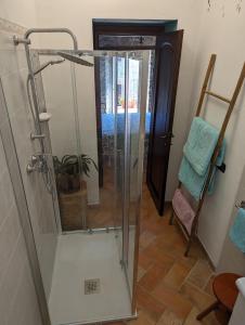 una doccia con porta in vetro in bagno di B&B il Tartufo a Sozzi