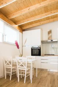 泰拉奇納的住宿－VILLA AMBROSIA 172 A，厨房配有白色橱柜和桌椅