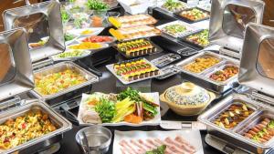 a table with many trays of different types of food at REX HOTEL Beppu in Beppu