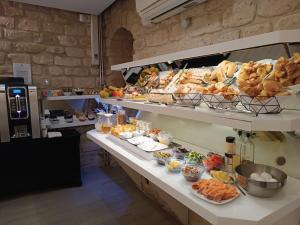 a bakery with a bunch of bread and pastries on shelves at Hotel Aida Marais in Paris