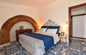 Schlafzimmer mit einem großen Bett und einem hölzernen Torbogen in der Unterkunft Amazing Home In Trappeto With Wifi in Trappeto