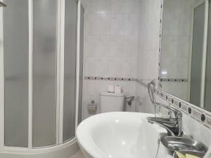 a white bathroom with a sink and a toilet at Calleja La Pimentera in Córdoba