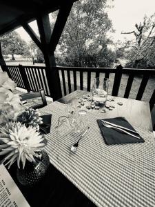 a black and white photo of a table with glasses and flowers at Demeure du Vallon - Chambres d'Hôtes de Charme in Azerat