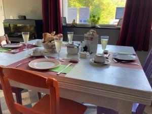 a table with plates and glasses of champagne on it at Liotte'sCorner Guesthouse in Sprimont