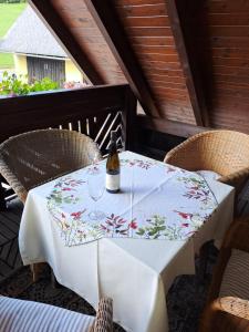 uma mesa com uma garrafa de vinho sentada num pátio em Privatzimmer Familie Pair/Schmoll em Spital am Semmering