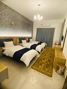 a bedroom with four beds and a rug at Motel Victoria Sky in Erbil