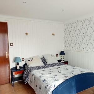 a bedroom with a bed and two tables with lamps at Maison La Belvérine in Beauvoir-sur-Mer