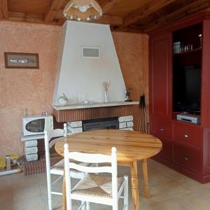 a table and chairs in a kitchen with a stove at Maison La Belvérine in Beauvoir-sur-Mer