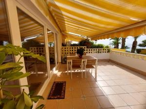 een patio met een tafel en stoelen op een balkon bij Bungalow Alkabir Playa in El Campello