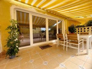 a patio with a table and chairs and a dining room at Bungalow Alkabir Playa in El Campello