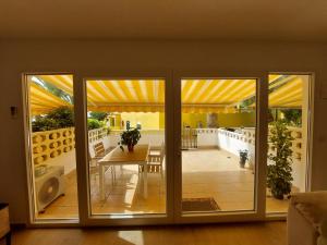 een patio met een tafel en glazen schuifdeuren bij Bungalow Alkabir Playa in El Campello