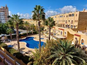 widok na ośrodek z basenem i palmami w obiekcie Bungalow Alkabir Playa w mieście El Campello