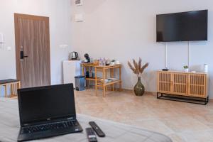 ブルガスにあるДизайнерско Студио в Модерна сграда -Молимаркс Делукс Студио Бургасのリビングルーム(ノートパソコン、テーブル付)