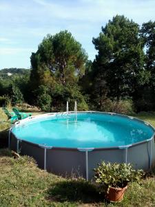 a large swimming pool in a yard with trees at Le Chausse à Brès Chambre d'hôtes 2 in Payzac