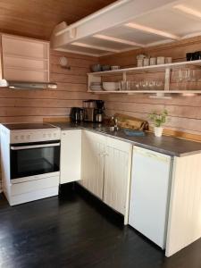 a kitchen with white cabinets and a white stove top oven at Fishermans cabin in Lofoten, Stamsund in Stamsund