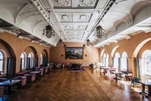 a large room with tables and chairs and windows at ROMANTICO BILOCALE CON PANORAMA MOZZAFIATO in Nova Levante