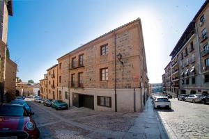 un grand bâtiment en briques dans une rue avec des voitures garées dans l'établissement Cervantes 5 Collection Alficen Delux, à Tolède