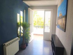 un pasillo con paredes azules y una puerta con una planta en EL EDEN De SALAMANCA, en Villares de la Reina