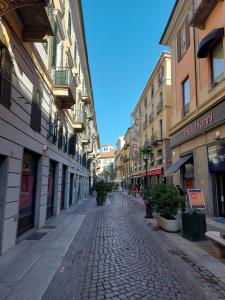 una calle adoquinada de piedra en una ciudad con edificios en La casina in città - The little flat in town en Alessandria