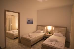 a hotel room with two beds and a mirror at Porto Psakoudia in Psakoudia