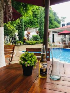 a bottle of beer sitting on a wooden table at HOTEL MACEO MELGAR in Melgar