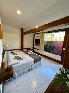 a bedroom with a bed and a large window at Pousada Villegaignon in Búzios