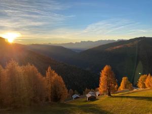a sunset on a hill with a view of a valley at Ferienwohnungen Peisserhof in Sillian