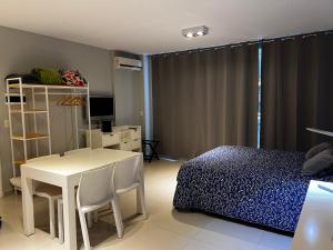 1 dormitorio con mesa, cama, mesa y sillas en Departamento en el Centro de Recoleta con pileta, parrilla, gym y laundry en Buenos Aires