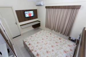 ein Schlafzimmer mit einem Bett und einem TV in der Unterkunft DiRoma Lacqua do I ao V - Caldas Novas, GO in Caldas Novas