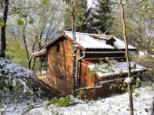 a small wooden cabin with snow on the roof at Cabane dans les bois avec vue sur les Pyrénées in Saint-Laurent-de-Neste