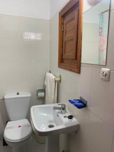 a white bathroom with a toilet and a sink at Hotel Playa in Mojácar