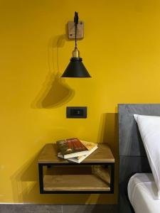 a table with a lamp on a yellow wall at Rambling Rooms in Campomarino