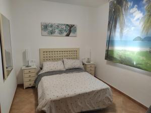 um quarto com uma cama e um quadro na parede em Islantilla primera linea de playa, piscina, parking na Islantilla