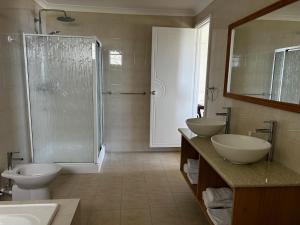 a bathroom with two sinks and a shower and two toilets at Beau Séjour Hotel in Victoria