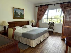ein Schlafzimmer mit einem großen Bett und einem Fenster in der Unterkunft Beau Séjour Hotel in Victoria