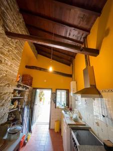 a kitchen with yellow walls and a stove top oven at Casa de Cotas in Cotas