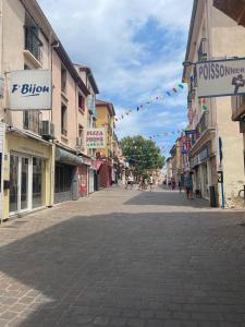 an empty street in a town with buildings and flags at Appartement ava in Argelès-sur-Mer +4 photos