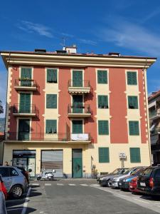 Un gran edificio con coches aparcados en un estacionamiento. en Ca' da Bianca, en Lavagna