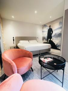 Hotel de la Couronne في إيكس لي بان: غرفة نوم بسرير وكرسي وطاولة
