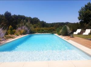 einen Pool im Garten mit Holzterrasse in der Unterkunft Les Prairies de Fenestrelle Spa & Piscine au calme in Aubagne