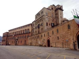 ein großes Backsteingebäude mit einer Straße davor in der Unterkunft PalermHost in Palermo