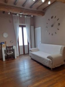1 dormitorio con 1 cama y reloj en la pared en La maison de nonnì, en Buonconvento