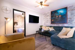 a living room with two couches and a tv at Villa Bella Vista Heritage Oasis in Podstrana