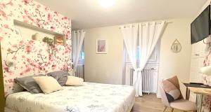 - une chambre avec un lit orné de fleurs sur le mur dans l'établissement Maison Bossoreil - Chambre Crémant, à Angers