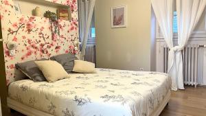 a bedroom with a bed with flowers on the wall at Chambre Crémant - Maison Bossoreil in Angers