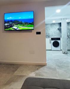 sala de estar con TV de pantalla plana en la pared en Estudio de Lujo, en Torrevieja